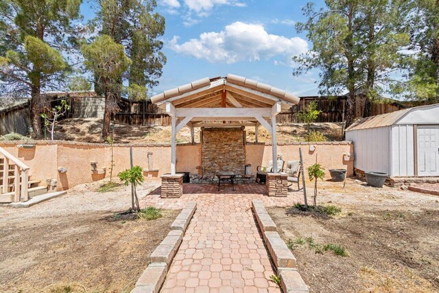 view of yard featuring a fenced backyard, a storage unit, a patio, and a gazebo