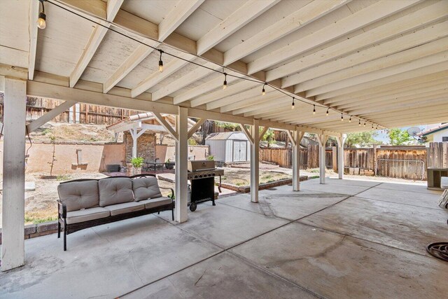 view of patio featuring area for grilling, an outdoor structure, a shed, a fenced backyard, and outdoor lounge area