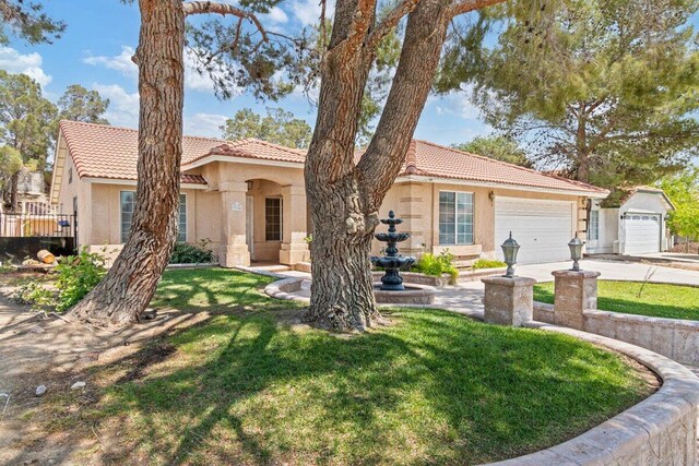 view of front of home with stucco siding, an attached garage, and a tile roof