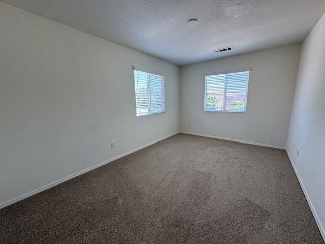 44316 Acacia St, Lancaster, CA 93535 - spare room with carpet flooring and a textured ceiling