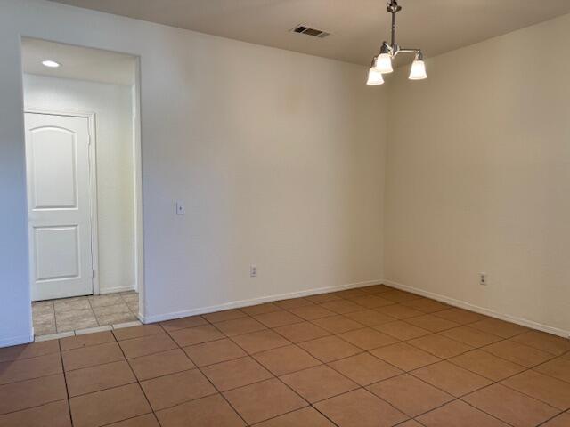 44316 Acacia St, Lancaster, CA 93535 - unfurnished room featuring light tile patterned floors and a chandelier
