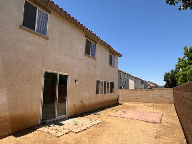 44316 Acacia St, Lancaster, CA 93535 - back of property featuring a fenced backyard, stucco siding, and a tiled roof