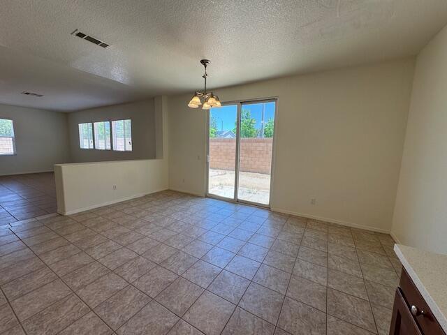 44316 Acacia St, Lancaster, CA 93535 - spare room with a chandelier, a textured ceiling, and light tile patterned floors