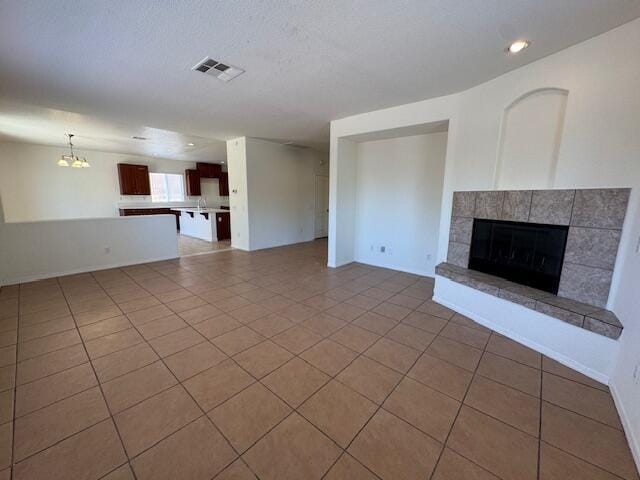 44316 Acacia St, Lancaster, CA 93535 - unfurnished living room with tile patterned flooring, a tiled fireplace, recessed lighting, and a chandelier