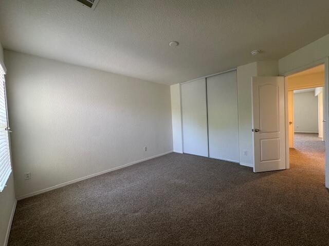 44316 Acacia St, Lancaster, CA 93535 - unfurnished bedroom with dark carpet and a closet