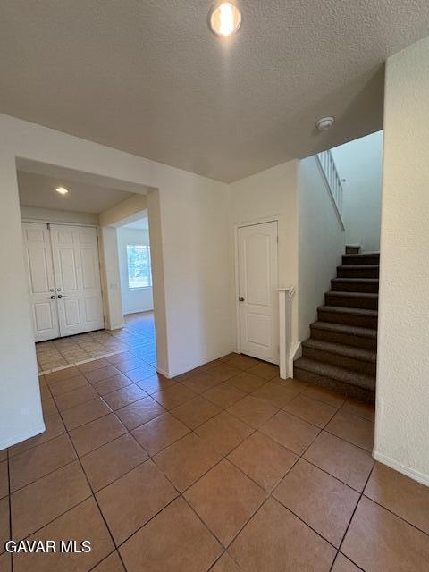 44316 Acacia St, Lancaster, CA 93535 - unfurnished room featuring light tile patterned floors, stairs, a textured ceiling, and recessed lighting