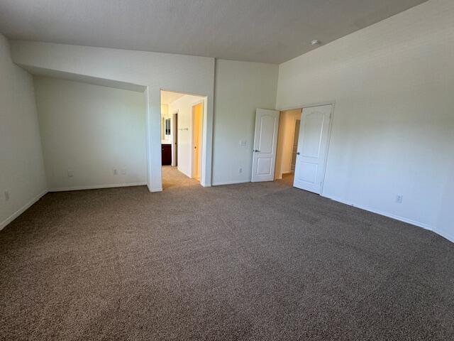 44316 Acacia St, Lancaster, CA 93535 - unfurnished bedroom with vaulted ceiling and dark carpet