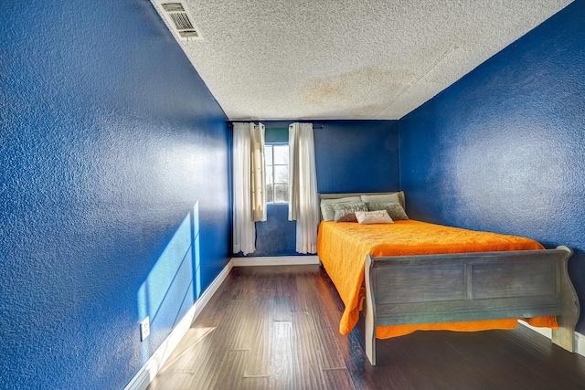 unfurnished bedroom with a textured ceiling and dark hardwood / wood-style floors