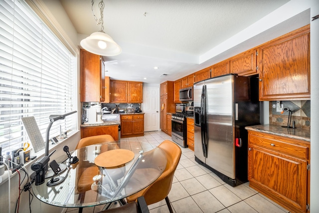kitchen featuring light tile patterned floors, appliances with stainless steel finishes, decorative backsplash, and a healthy amount of sunlight