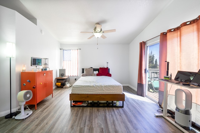 bedroom featuring baseboards, wood finished floors, multiple windows, and access to exterior