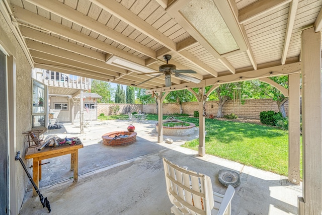 view of patio / terrace with a ceiling fan, an outdoor structure, a fenced backyard, a storage unit, and a fire pit