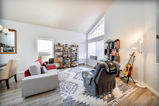 living area featuring baseboards, high vaulted ceiling, and wood finished floors