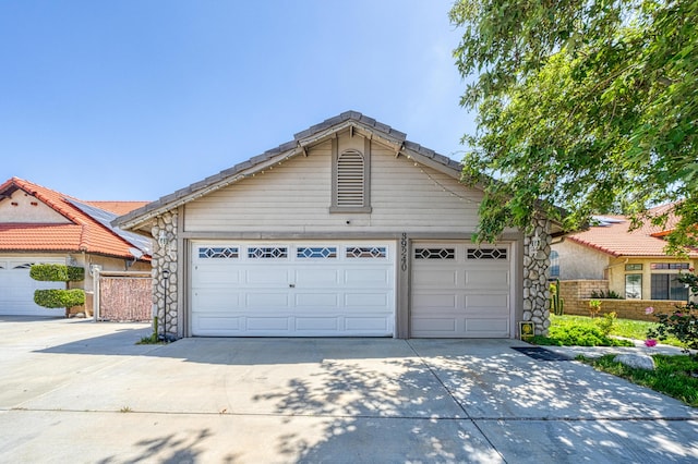 ranch-style house with a garage, fence, an outdoor structure, and concrete driveway