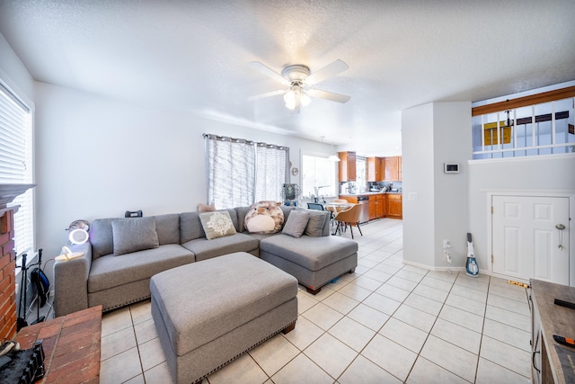 living room featuring ceiling fan, a fireplace, and light tile patterned flooring