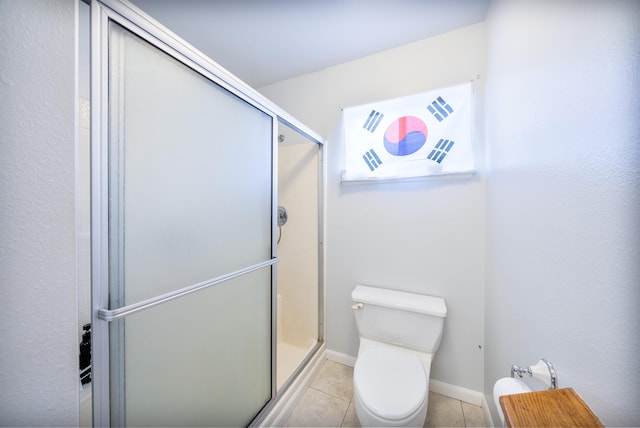 full bath featuring toilet, baseboards, a shower stall, and tile patterned flooring
