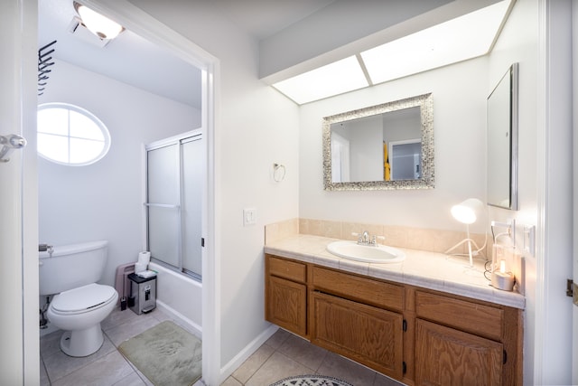 bathroom featuring vanity, tile patterned flooring, toilet, and shower / bath combination with glass door