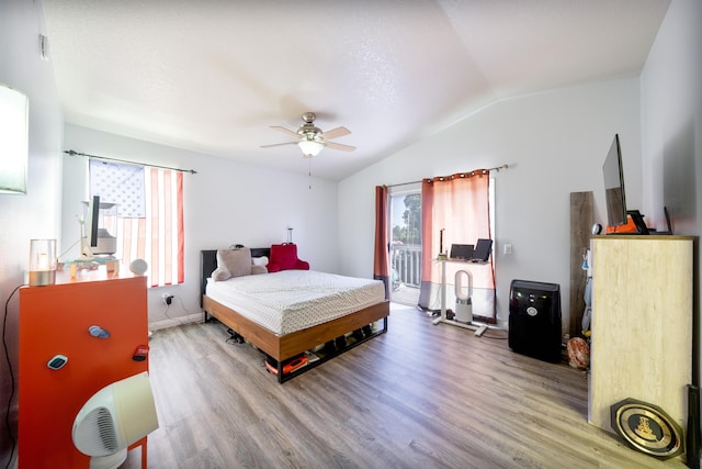 bedroom with a ceiling fan, wood finished floors, baseboards, lofted ceiling, and access to outside