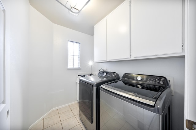clothes washing area with cabinet space, independent washer and dryer, baseboards, and light tile patterned flooring