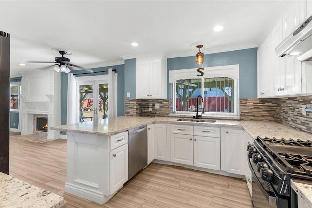 kitchen with french doors, range hood, backsplash, white cabinets, and appliances with stainless steel finishes