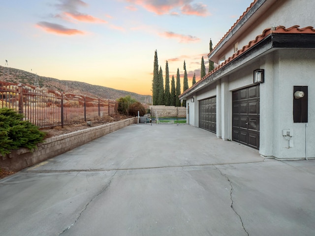 property exterior at dusk featuring a mountain view and a garage