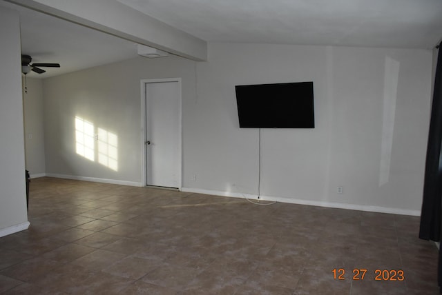 empty room featuring ceiling fan and lofted ceiling with beams