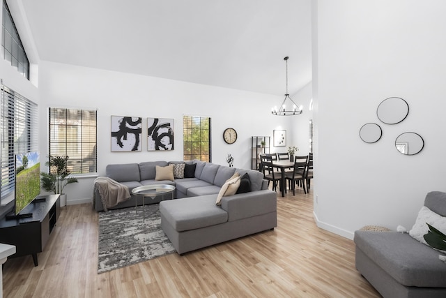 2012 Comstock Ct, Palmdale, CA 93551 - living area with a chandelier, high vaulted ceiling, light wood-style floors, and baseboards