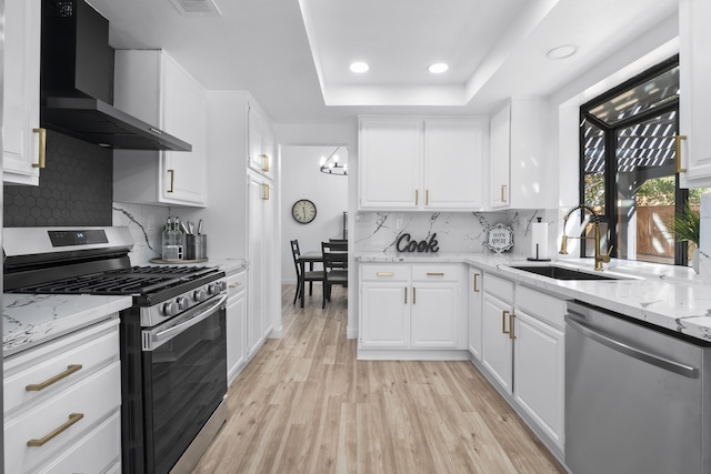 2012 Comstock Ct, Palmdale, CA 93551 - kitchen with appliances with stainless steel finishes, wall chimney range hood, a sink, a raised ceiling, and recessed lighting
