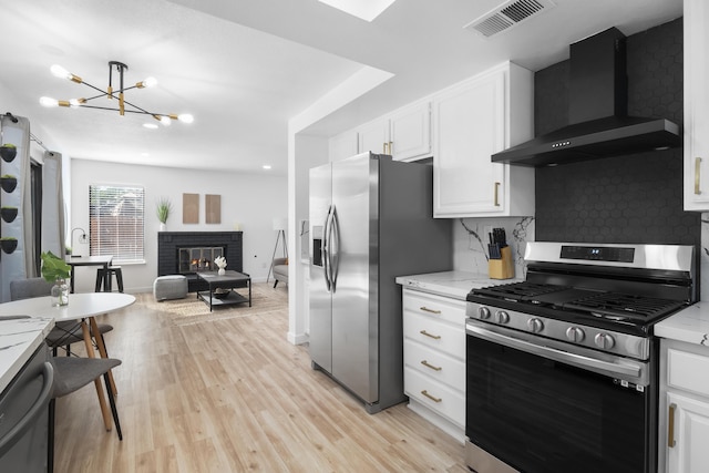2012 Comstock Ct, Palmdale, CA 93551 - kitchen with appliances with stainless steel finishes, wall chimney exhaust hood, tasteful backsplash, a chandelier, and white cabinets