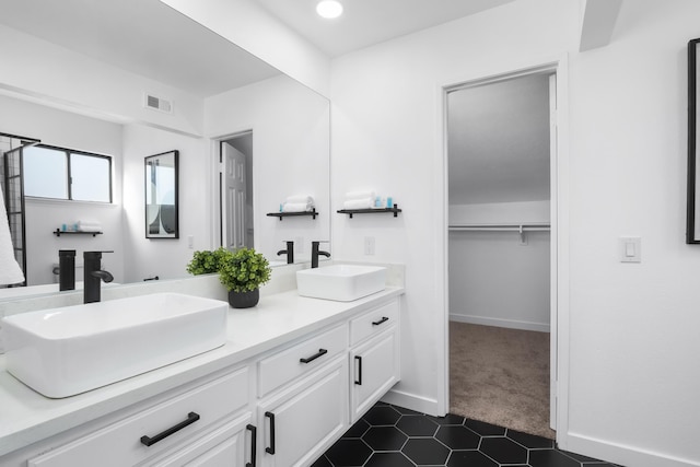 2012 Comstock Ct, Palmdale, CA 93551 - bathroom featuring double vanity, tile patterned floors, a walk in closet, and baseboards