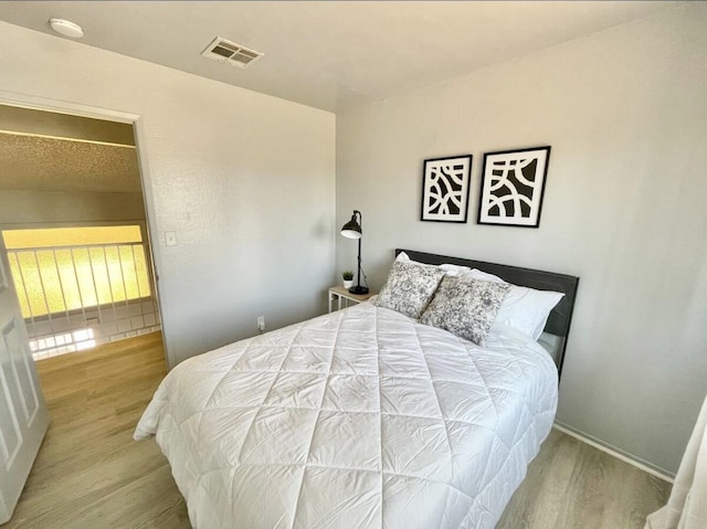 bedroom with wood finished floors and visible vents