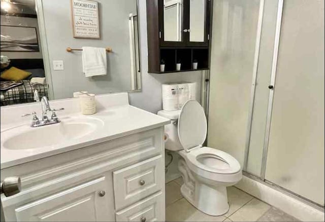 full bath featuring toilet, a shower stall, vanity, and tile patterned floors