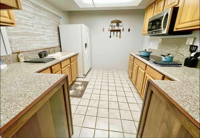 kitchen featuring light tile patterned floors, tasteful backsplash, stainless steel microwave, a sink, and white fridge with ice dispenser