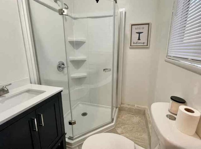 bathroom with tile patterned flooring, a shower stall, toilet, and vanity