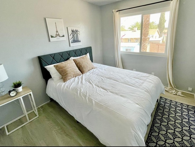 bedroom featuring wood finished floors and baseboards