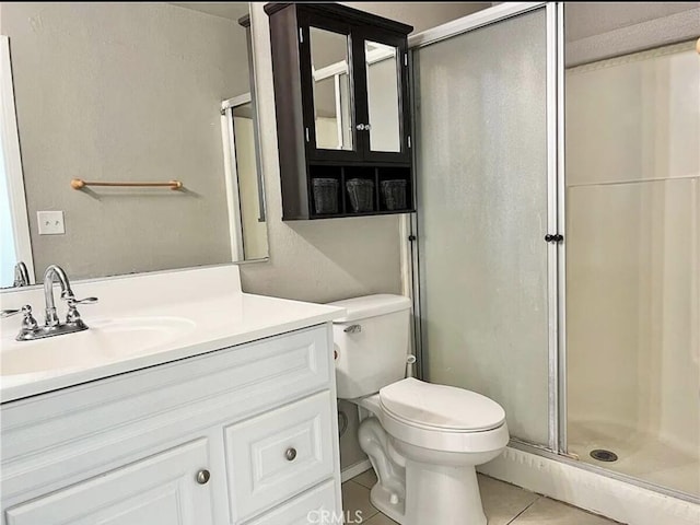 bathroom with a stall shower, tile patterned flooring, vanity, and toilet