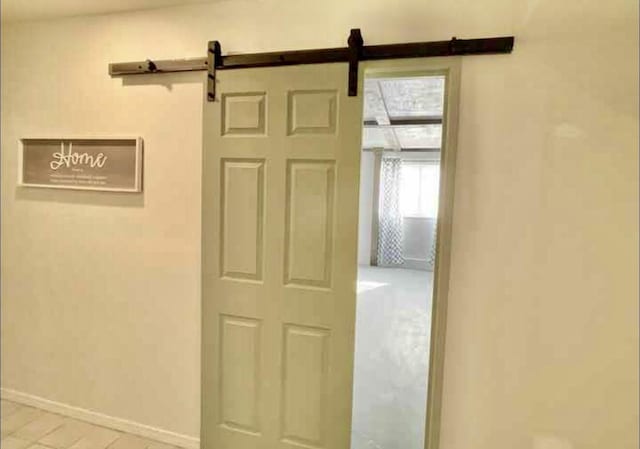 interior space with a barn door and baseboards