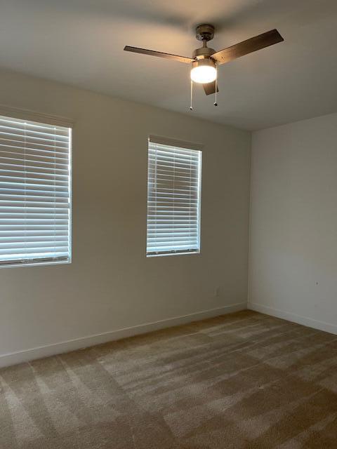 carpeted empty room featuring ceiling fan