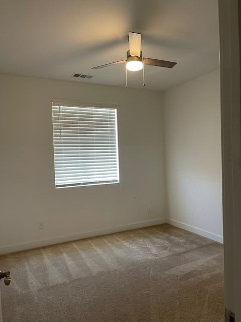 empty room featuring carpet flooring and ceiling fan