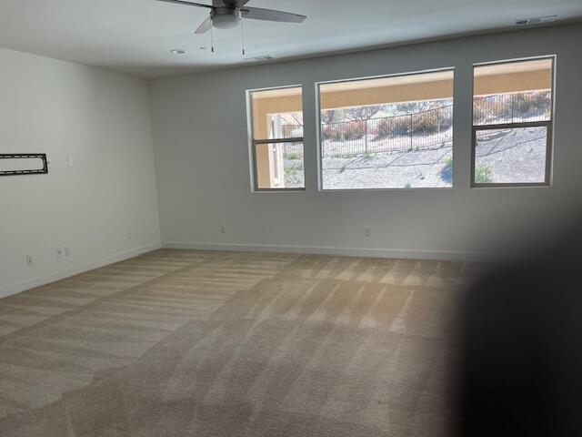 carpeted spare room with ceiling fan