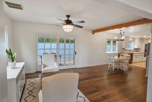 living room featuring ceiling fan with notable chandelier, a wealth of natural light, and dark hardwood / wood-style floors