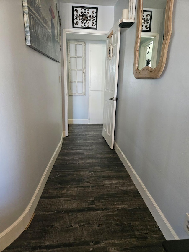 hallway with dark wood finished floors and baseboards