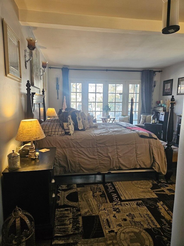 bedroom featuring french doors, multiple windows, and beamed ceiling