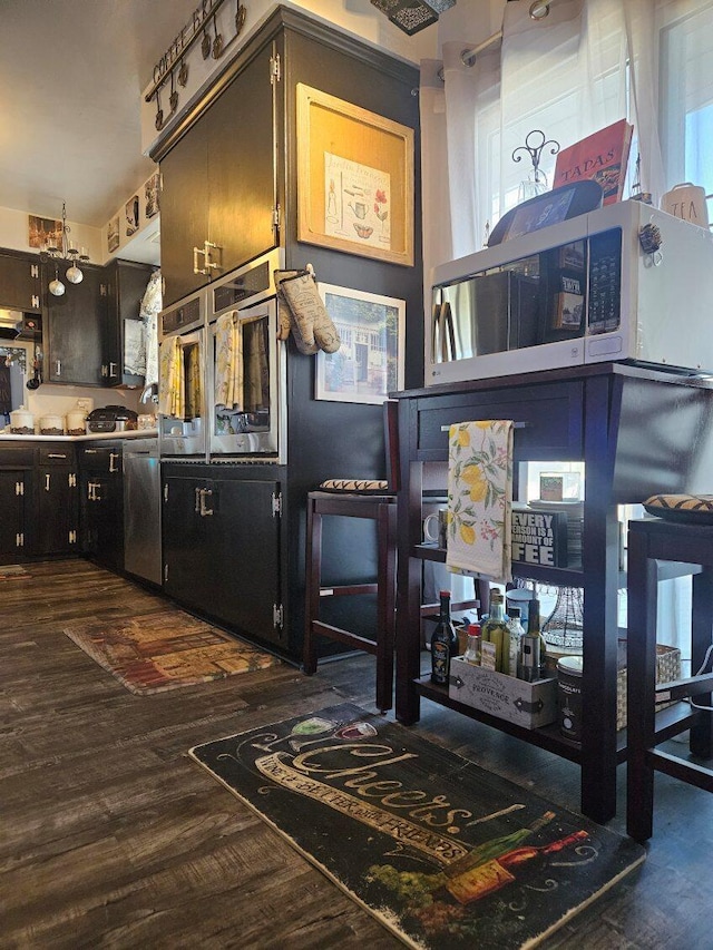 bar featuring dishwasher and dark wood-style floors