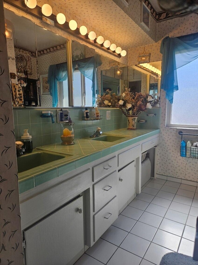 full bathroom featuring wallpapered walls, double vanity, tile patterned flooring, and a sink