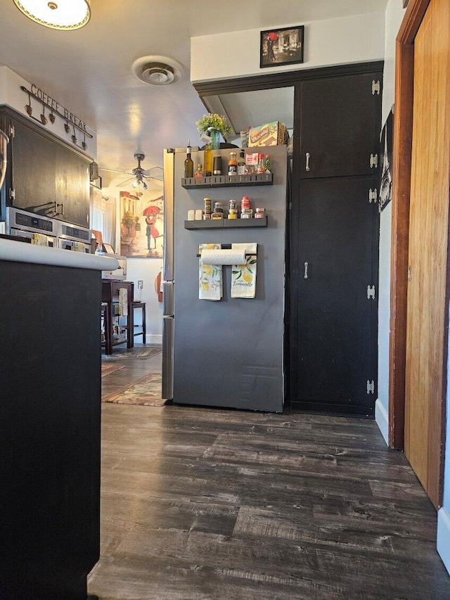kitchen featuring a ceiling fan, wood finished floors, visible vents, and freestanding refrigerator