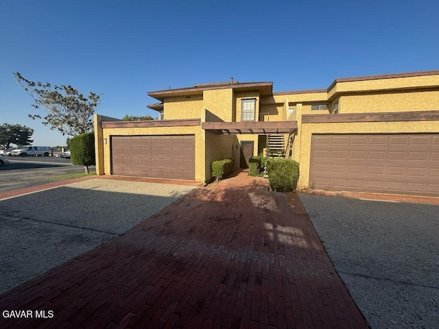 42821 W 15th St Unit 1, Lancaster, CA 93534 - view of front facade with stucco siding, an attached garage, and decorative driveway