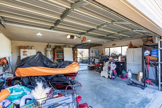 garage featuring strapped water heater, a garage door opener, and freestanding refrigerator