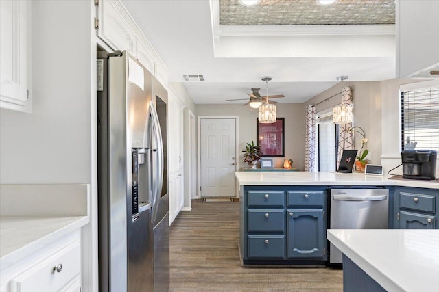 kitchen with appliances with stainless steel finishes, light countertops, white cabinets, and blue cabinetry