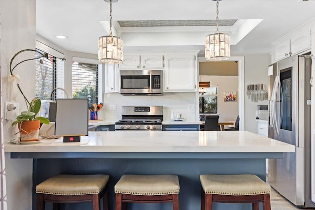 kitchen featuring white cabinets, a breakfast bar area, and stainless steel appliances