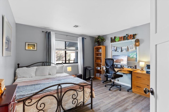 bedroom featuring baseboards, visible vents, and light wood-style floors